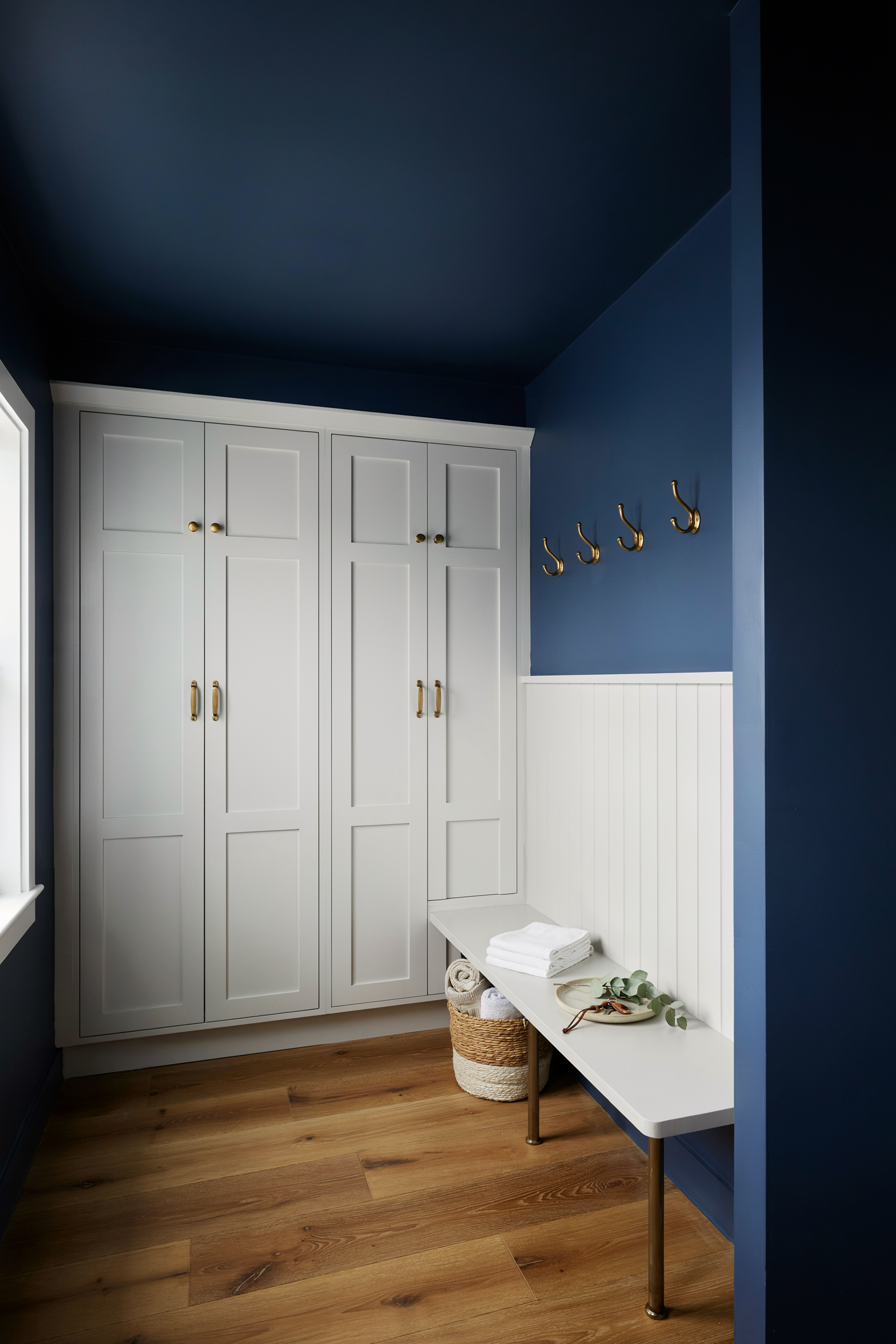 Dark Painted Mudroom With White Cabinetry